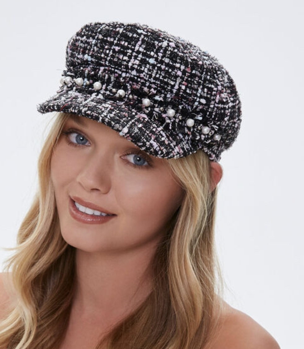Model is wearing a black and white tweed cabbie hat
