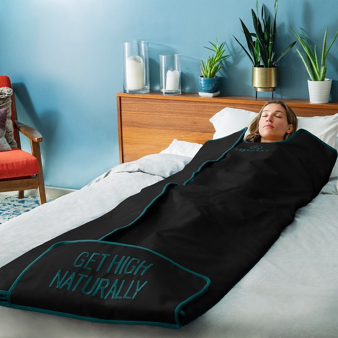 A person laying inside of the sauna blanket