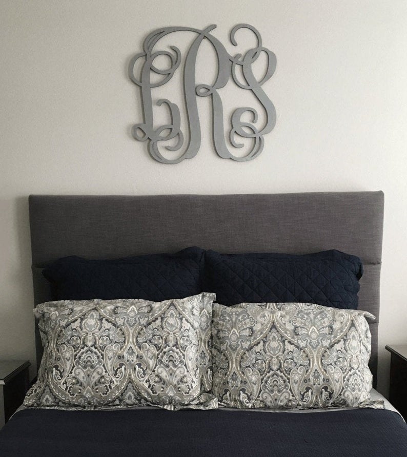 a monogram sign in gray over a bed