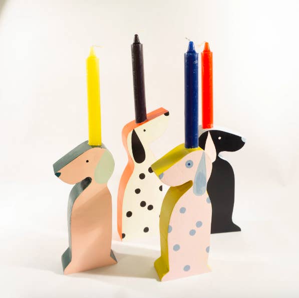 Wooden candle holders in the shape of sitting dogs, all in colorful patterns 