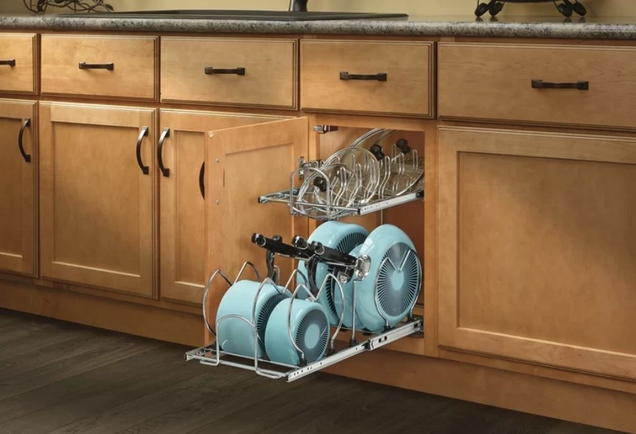 Metal kitchen divider unit in cabinet holding blue pots and pans