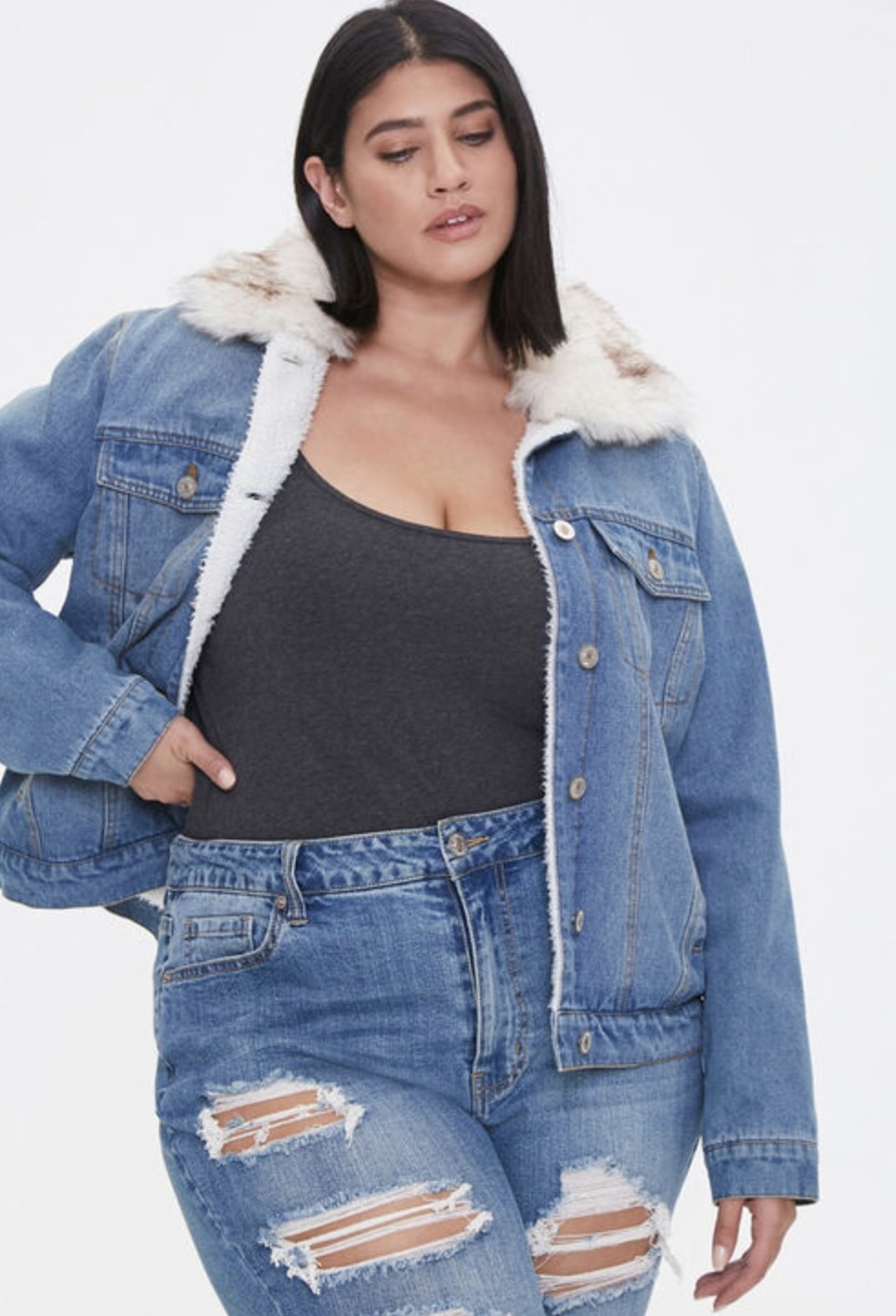 Model is wearing a denim fur trim jacket with blue jeans and a black top