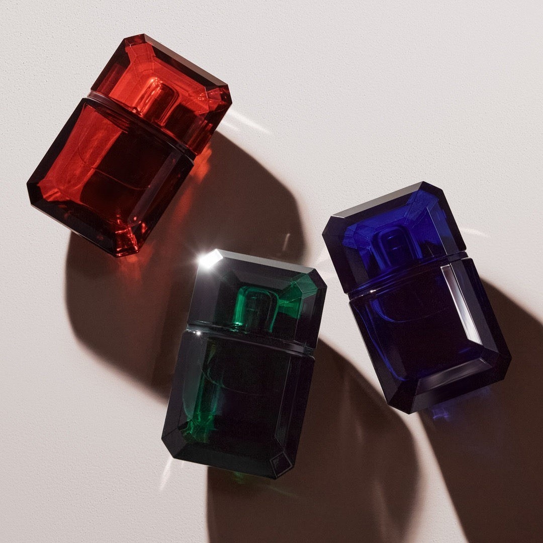 a red, a green, and a blue emerald stone shaped perfume
