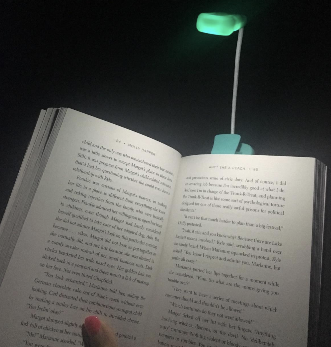 a reviewer photo of the light brightening up a book page in the dark