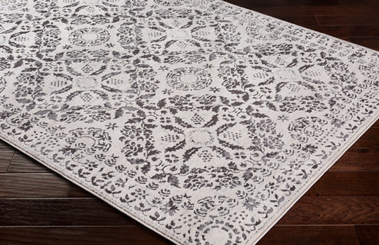 the gray and white rug with floral designs on it