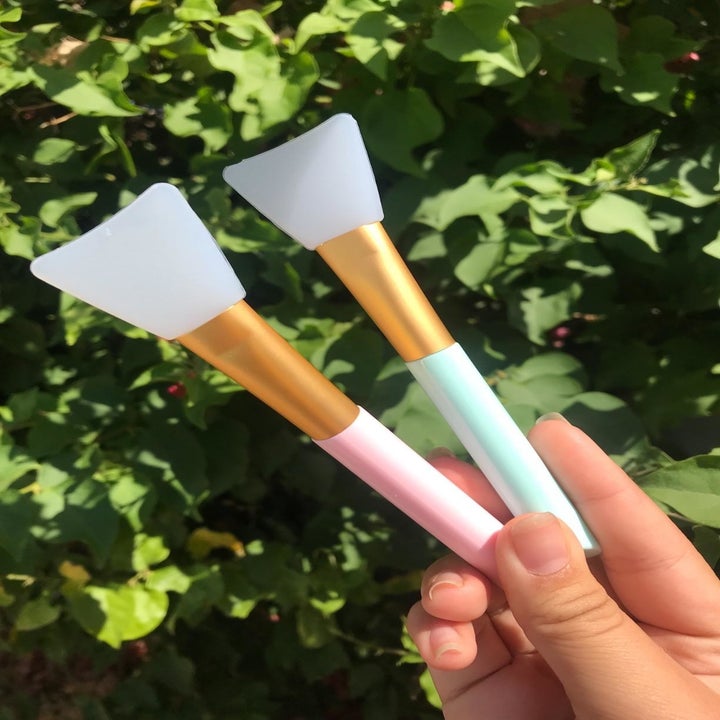 A different reviewer holding the pink and green applicators