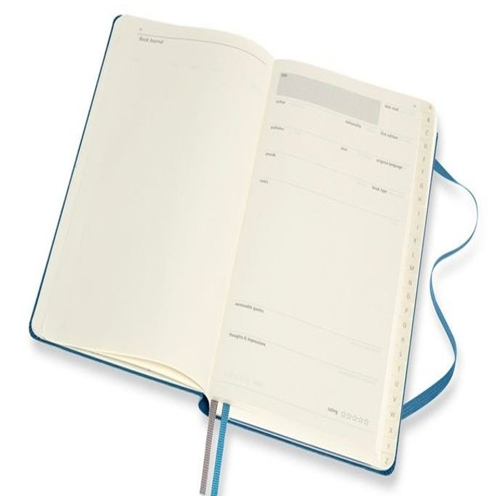 the interior of the book journal showing spaces to fill in things like thoughts on the book