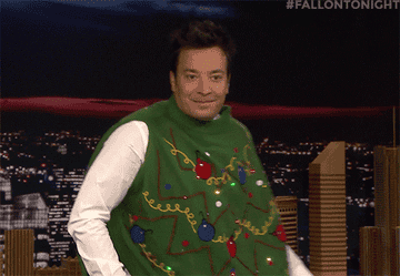 A Gif of Jimmy Fallon dancing in an oversized Christmas tree sweater vest 