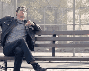 A GIF of the Black Keys sitting on a bench sharing donuts