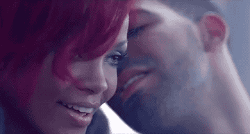 A GIF of Drake whispering in Rihanna&#x27;s ear from the music video for &quot;What&#x27;s My Name?&quot;