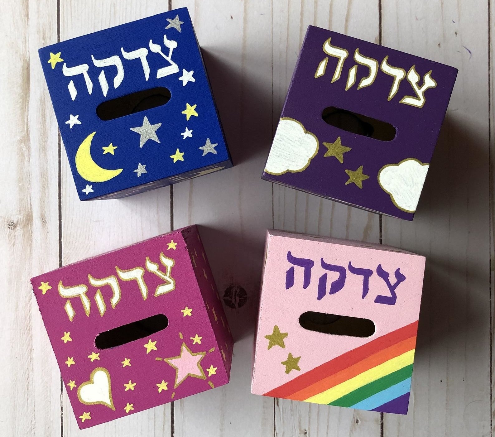four of the different painted tzedakah boxes