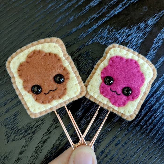 Two paperclips shaped like a slice of toast with peanut butter and jelly