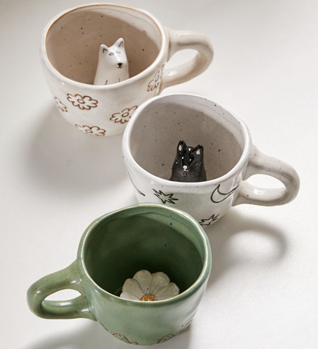 Three mugs with figurines inside