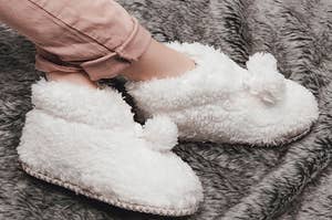 The fuzzy slipper booties with pom poms