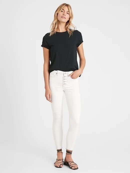 person wearing white skinny jeans and a black t-shirt