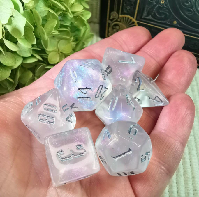 A person holds seven polyhedral dice in their open palm