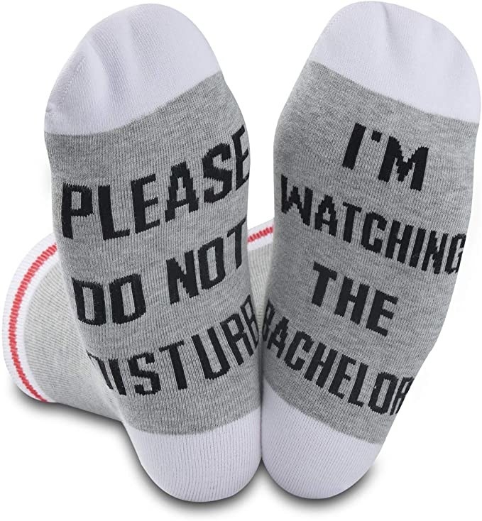 Socks that read &quot;please do not disturb...I&#x27;m watching The Bachelor&quot; on the base of the foot