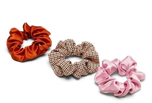 orange scrunchie, houndstooth scrunchie, and a pink scrunchie