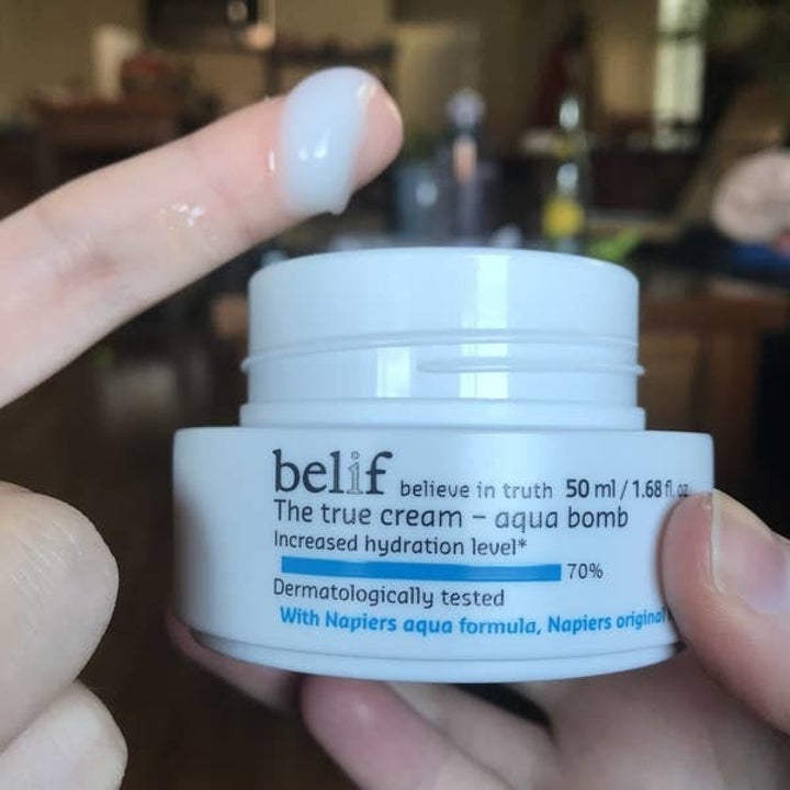 writer's finger dipped into the moisturizer showing it's light blue gel-like texture