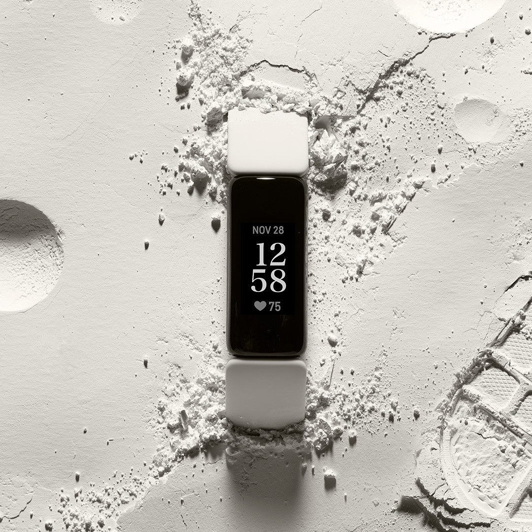 A Fitbit tracker on a chalky background