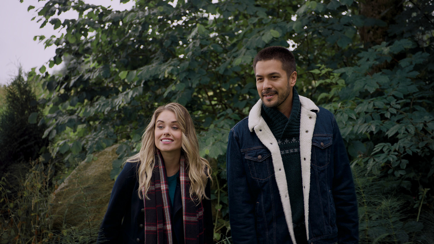 Stephanie Bennett and Marco Grazzini smile away from the camera with with trees behind them while walking