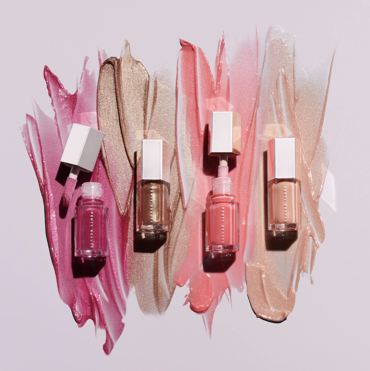 The mini lip glosses in deep pink, brown, light pink, and a peachy nude