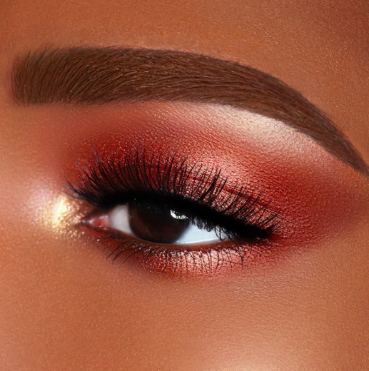 A person wears a sparkly dusty orange eyeshadow