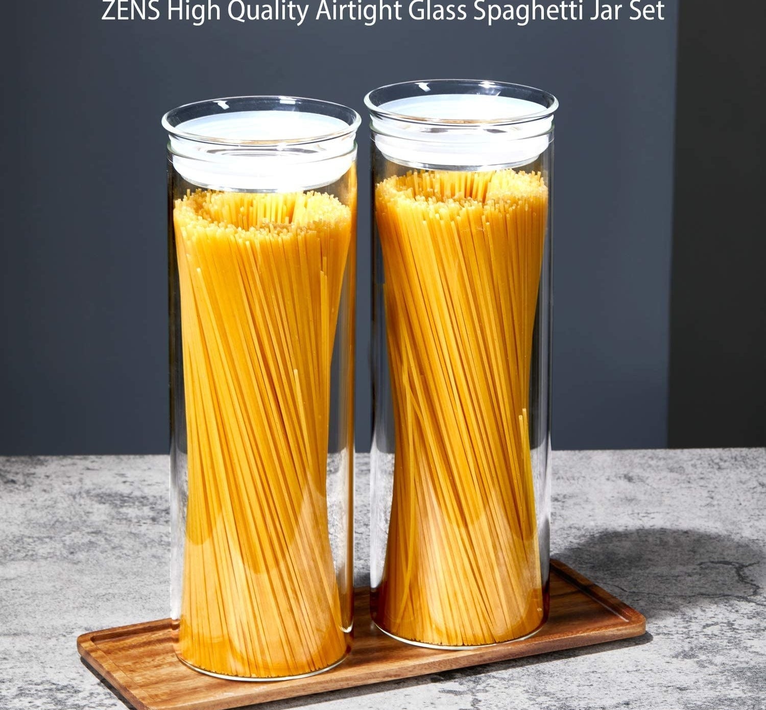 A pair of tall skinny glass canisters filled with spaghetti noodles