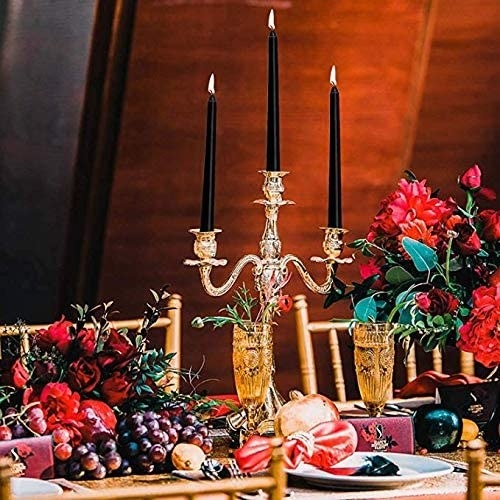 An elaborate candelabra perched on an elegant dining table and filled with the dripless candles