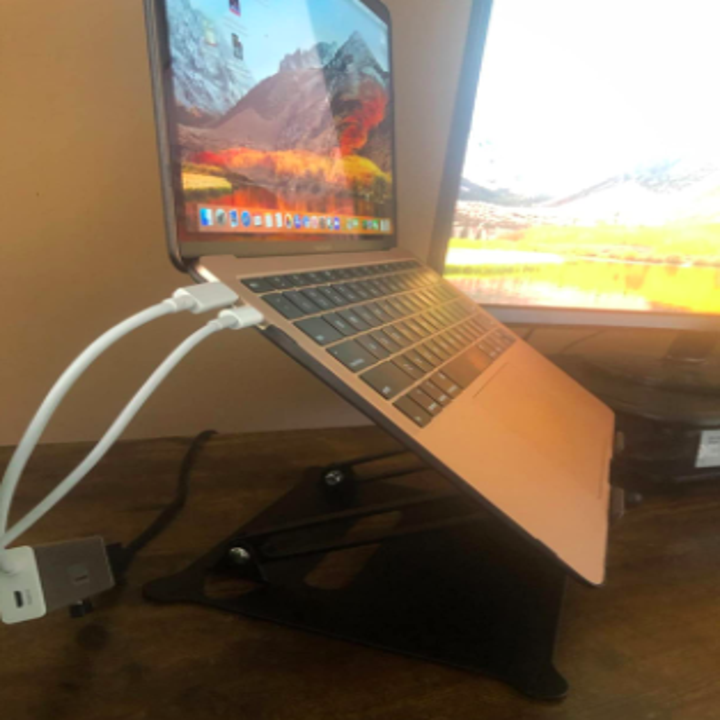 reviewer pic of side angle of the riser securely holding a macbook open 