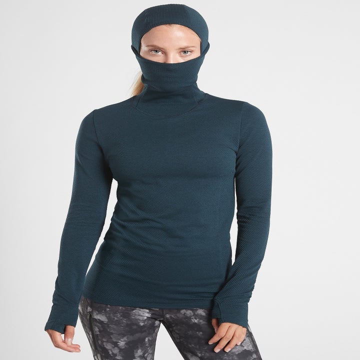 A model wearing the top with their face fully covered, except for the eyes
