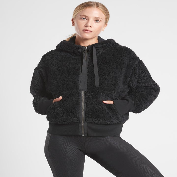 A model wearing the zippered jacket with the sherpa side out
