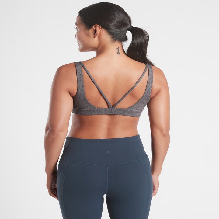 A model showing the v-neck-straps toward the back of the bra in Grey Heather