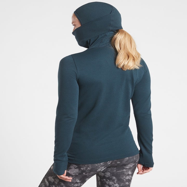 A model showing the back of the top has a hole for a ponytail