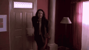 gif of tommy wiseau in the movie &quot;the room&quot; walking into a room saying &quot;I have something for youuu&quot;
