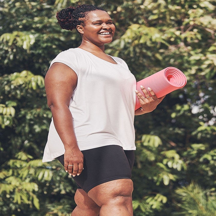 A model wearing the shorts while holding a yoga mat