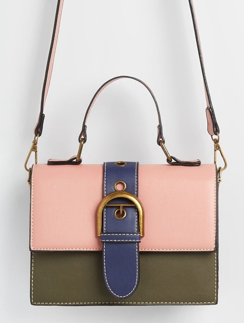 olive green, light pink, and navy blue square purse with short and long handles and a gold buckle