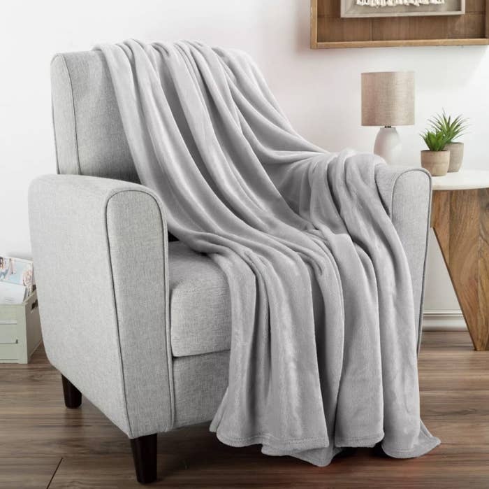 the oversized fleece throw draped over a gray chair 