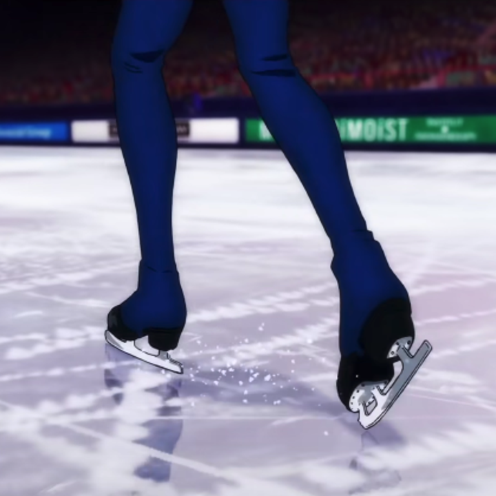 A close up of Victor's skates while he's in a figure skating arena