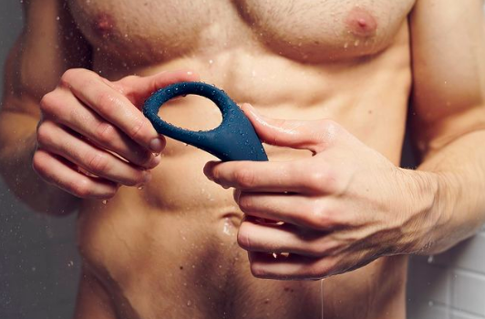 Person holding ring sex toy while in shower