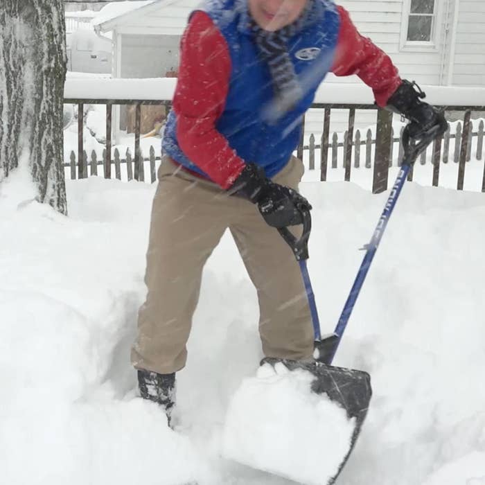 A person using the shovel while it snows