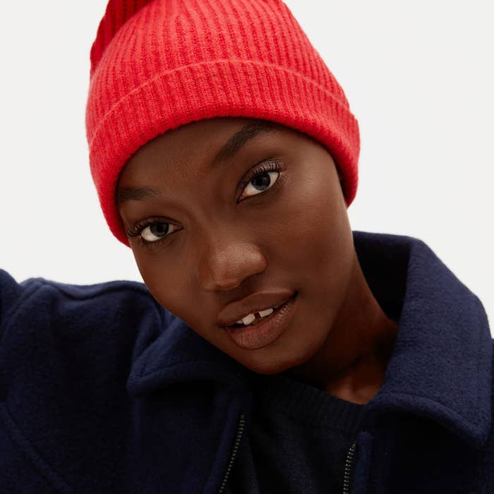 a model in a bright pink beanie