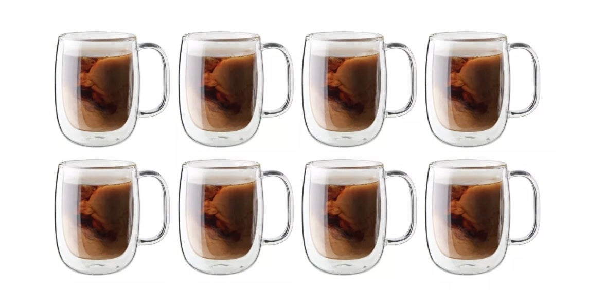 a set of 8 mugs with coffee inside of it 