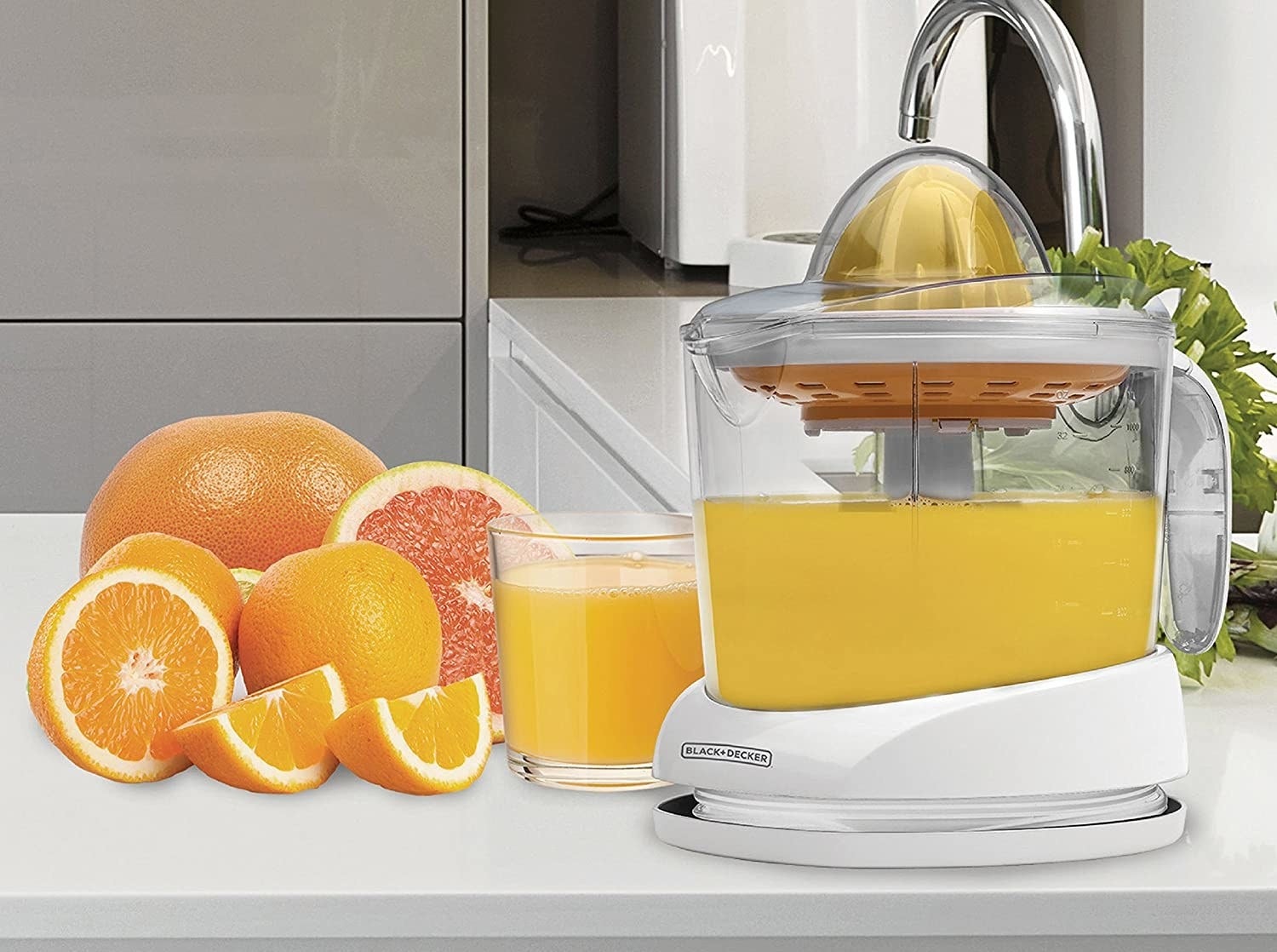 A citrus juicer surrounded by fruit on a kitchen counter