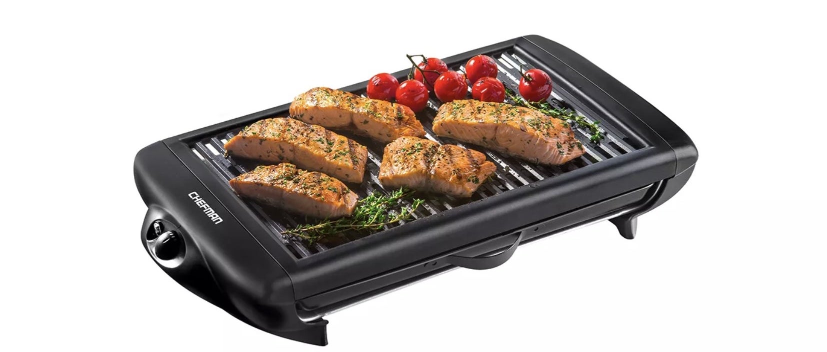 the smokeless indoor grill with salmon, tomatoes, and fresh herbs on it 
