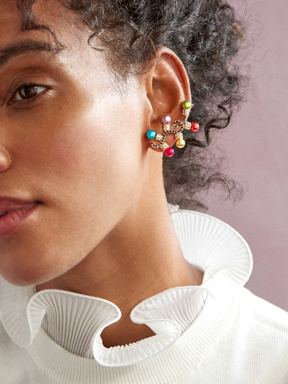 a model wearing ear crawlers that look like christmas lights on a string