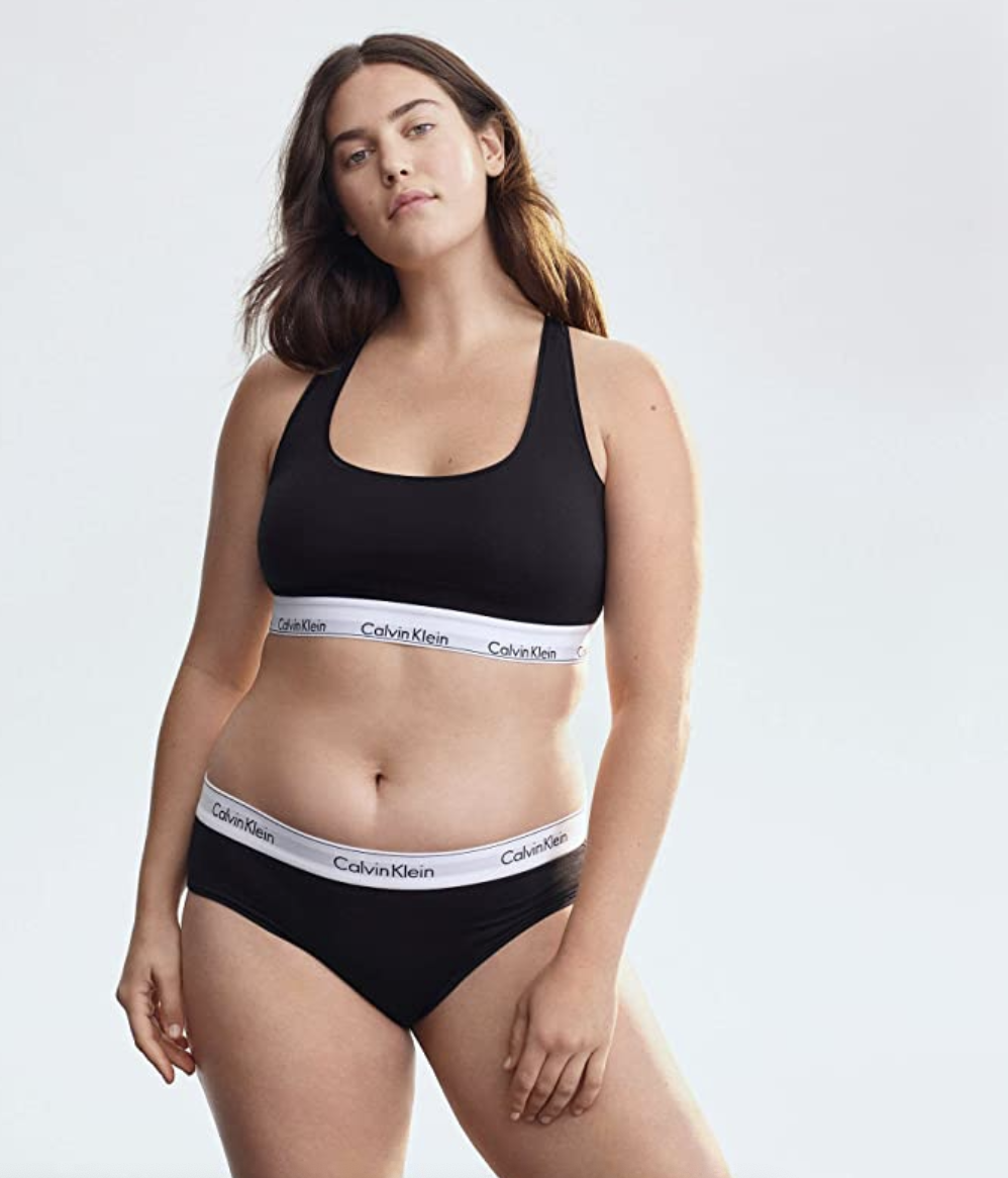 model in a black bralette with a white band with the calvin klein logo 