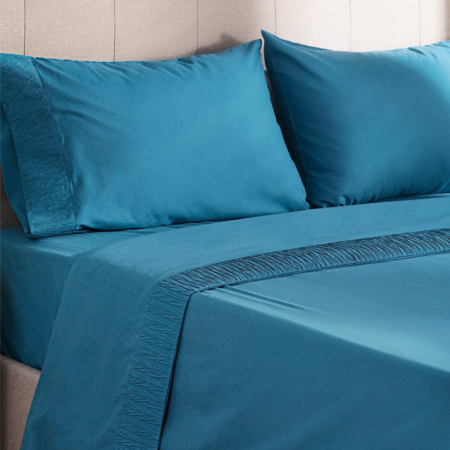The sheets in teal on a bed