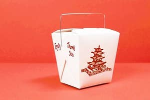 Chinese takeout box placed in front of a red background.
