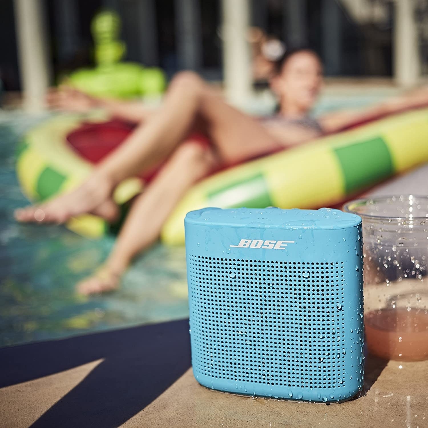 A small Bluetooth speaker on the edge of a pool